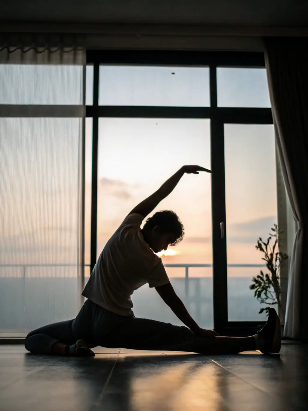 A person performing a hamstring stretch while sitting on the floor, legs extended, reaching towards their toes. The image should convey proper form and posture, suitable for a physiotherapy self-help guide.